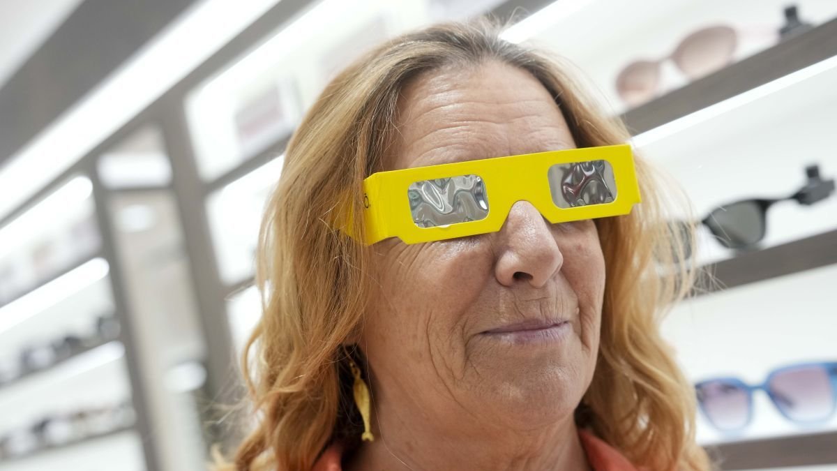 Mujer probándose unas gafas con filtro solar homologado.