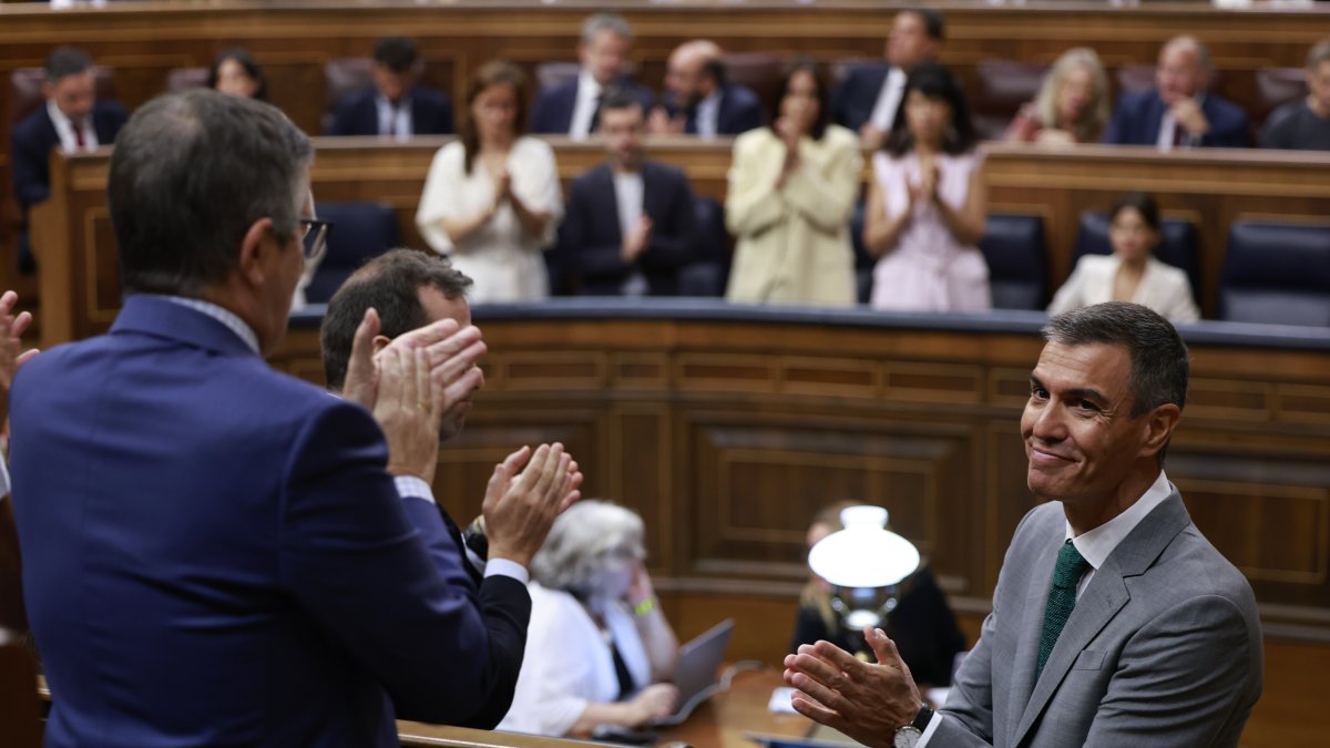 El presidente del Gobierno, Pedro Sánchez (d), recibe el aplauso de la bancada socialista en el Congreso de los Diputados.