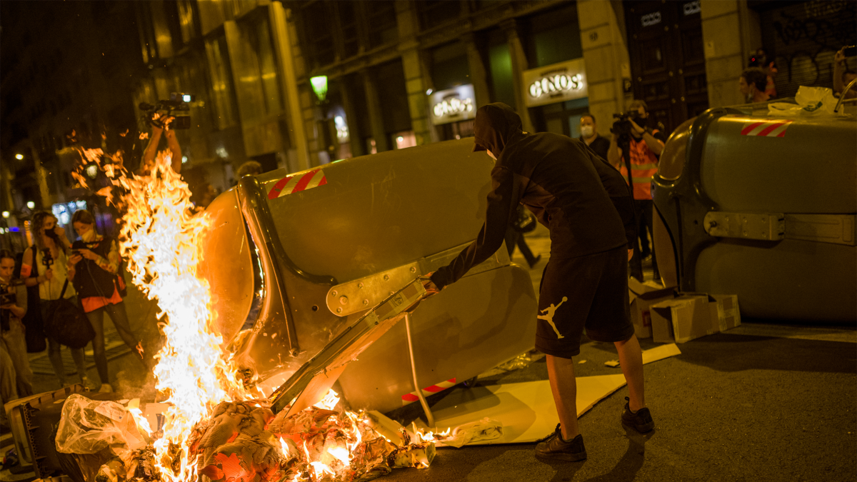Archivo - Un manifestante empieza a quemar un contenedor durante una manifestación por el referéndum del 1-O en Cataluña, a 1 de octubre de 2021, en Barcelona, Cataluña (España).