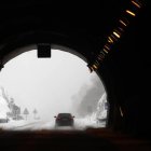 Vista de una carretera nevada atravesando un túnel.