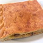 Una empanada casera con masa de pan dorada y relleno sabroso, ejemplo de las muchas variantes tradicionales que se preparan en distintas regiones.