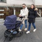 Una pareja camina frente al Auditorio Ciudad de León con su bebé en el carrito.