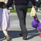 Un padre lleva a su hija de la mano tras recogerla a la salida del colegio.