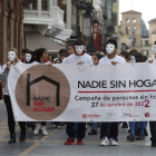 Estudiantes recorren el centro de León con la pancarta de Cáritas. FERNANDO OTERO