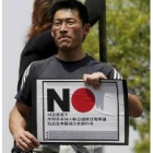 Un joven chino porta una pancarta en la que se pide el boicot a los productos japoneses