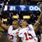 Los jugadores Osi Umeniyora (izquierda) y Devin Thomas de los Giants de Nueva York celebran la victoria ante los Patriots, en el estadio Lucas Oil de Indianápolis.