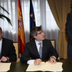 Miguel Sebastián y Francisco Fernández firman el convenio, Antonio Silván da fe de ello.