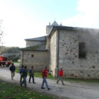 Dos bomberos apagan los últimos rescoldos del fuego.