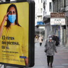 Una calle de Oviedo con un cartel de la campaña contra el coronavirus en Asturias. J. L. CEREIJIDO