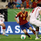 Andrés Iniesta controla el balón ante los jugadores de Georgia, Tornike Okriashvili, izquierda, y Akaki Khubutia, durante el partido clasificatorio para el Mundial.