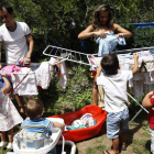 Los cinco hijos de Lorena Castellanos y Raúl Santos ayudan a tender la ropa en el jardín de su casa.