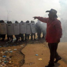 Un hombre camina frente a un grupo de soldados.