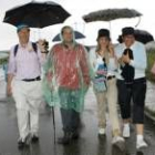 Amilivia, en el centro, tuvo que taparse para que la lluvia no le mojara en su tramo por el Camino