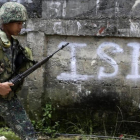 Un soldado filipino patrulla por un vecindario despues de un bombardeo durante los combates contra el EI.