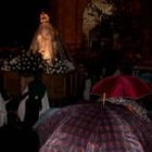 Los paraguas recibieron a una Virgen de la Esperanza cubierta por un plástico