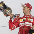 Vettel presume en el podio de su trofeo como ganador en el GP de Baréin. XHEMAJ