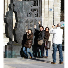 Unos turistas en el monumento de la Plaza de la Catedral.
