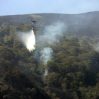 Uno de los helicópteros de extinción, actuando sobre el fuego, en Cármenes.