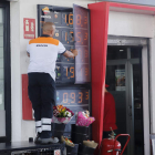 Un empleado de una gasolinera cambia los precios de los combustibles en un tablón. SERGIO ORDÚÑEZ