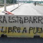Pintada aparecida sobre una de las barreras del puente exigiendo la apertura de este enlace entre Pu