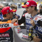 Los españoles Jorge Lorenzo y Dani Pedrosa se saludan tras clasificarse primero y segundo.