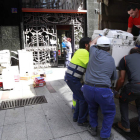 Operarios trasladan material de la sede municipal del ayuntamiento de León tras el incendio.