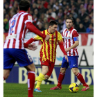 Messi controla un balón rodeado por jugadores del Atlético de Madrid.