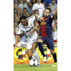 El centrocampista del Madrid Mesut Ozil lucha un balón con el defensa del Barça Jordi Alba.