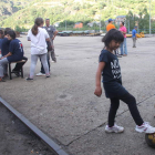 Un perro y una pequeña juguetean en el exterior de la bocamina de Santa Cruz.