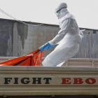 Un trabajador sanitario carga con el cuerpo de una de las víctimas del ébola en Monrovia.