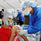 Un menor recibe la vacuna en Bogotá en plena celebración de Halloween. CARLOS ORTEGA