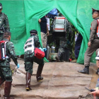 Personal médico accede a una zona restringida durante los preparativos para transportar a los niños rescatados al hospital en los alrededores de la cueva.