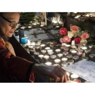 Una mujer enciende una vela en la plaza de la República de París en memoria de las víctimas de los atentados en la noche del viernes en el centro de la capital francesa.