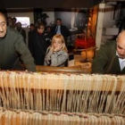 Dos expertos artesanos del pueblo maragato y tejedor de Val de San Lorenzo manejan el telar expuesto