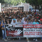 Dos mineros muestran su apoyo a los encerrados asomados a la ventana del despacho del PSOE en el Palacio de los Guzmanes.