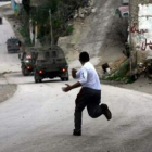 Un hombre palestino lanza piedras a las tropas israelíes durante un enfrentamiento en la aldea de Te