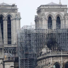 Varios bomberos trabajan en lo alto de una de las torres de la catedral de Nôtre Dame.