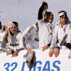 Özil, Benzema, Pepe y Marcelo, en primera fila, festejan la Liga en el autobús del Real Madrid que llevó al equipo desde el Santiago Bernabéu hasta la plaza de Cibeles, donde esperaban miles de aficionados.