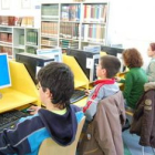 Un grupo de escolares leen en la biblioteca de Trobajo.