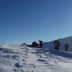 Compañeros del esquiador accidentado y miembros del equipo de rescate, en El Cornón