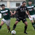 Tornero, en el centro de la imagen, controla el balón frente a dos rivales del Coruxo.