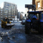 Operarios y maquinaria quitando ayer montones de nieve en el centro de la ciudad.