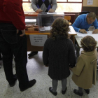 Dos niños siguen la votación en un colegio.