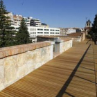 Vista del primer tramo paseable de la muralla de León, con suelo de tablillas de madera. Al fondo, l