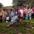 Los pequeños observaban atentos a un compañero plantando el árbol