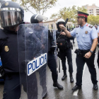 Agentes antidisturbios de la Policía Nacional y de los Mossos D'Esquadra discuten frente al Instituto Can Vilumara de L'Hospitalet de Llobregat.