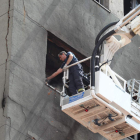 Un bombero revisando la grieta de la parte trasera del edificio municipal más siniestrado.