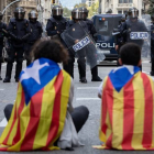 Varios manifestantes se encaran a los agentes antidisturbios durante las protestas que se están produciendo ante la comisaria de la Policía Nacional de Via Laietana. EFE / Enric Fontcuberta
