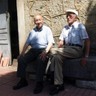Antonio Casado y Enrique del Campo sentados a la puerta en Lario.