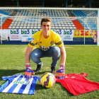 Kepa Arrizabalaga posa en el césped de El Toralín con las camisetas de la Deportiva y España.